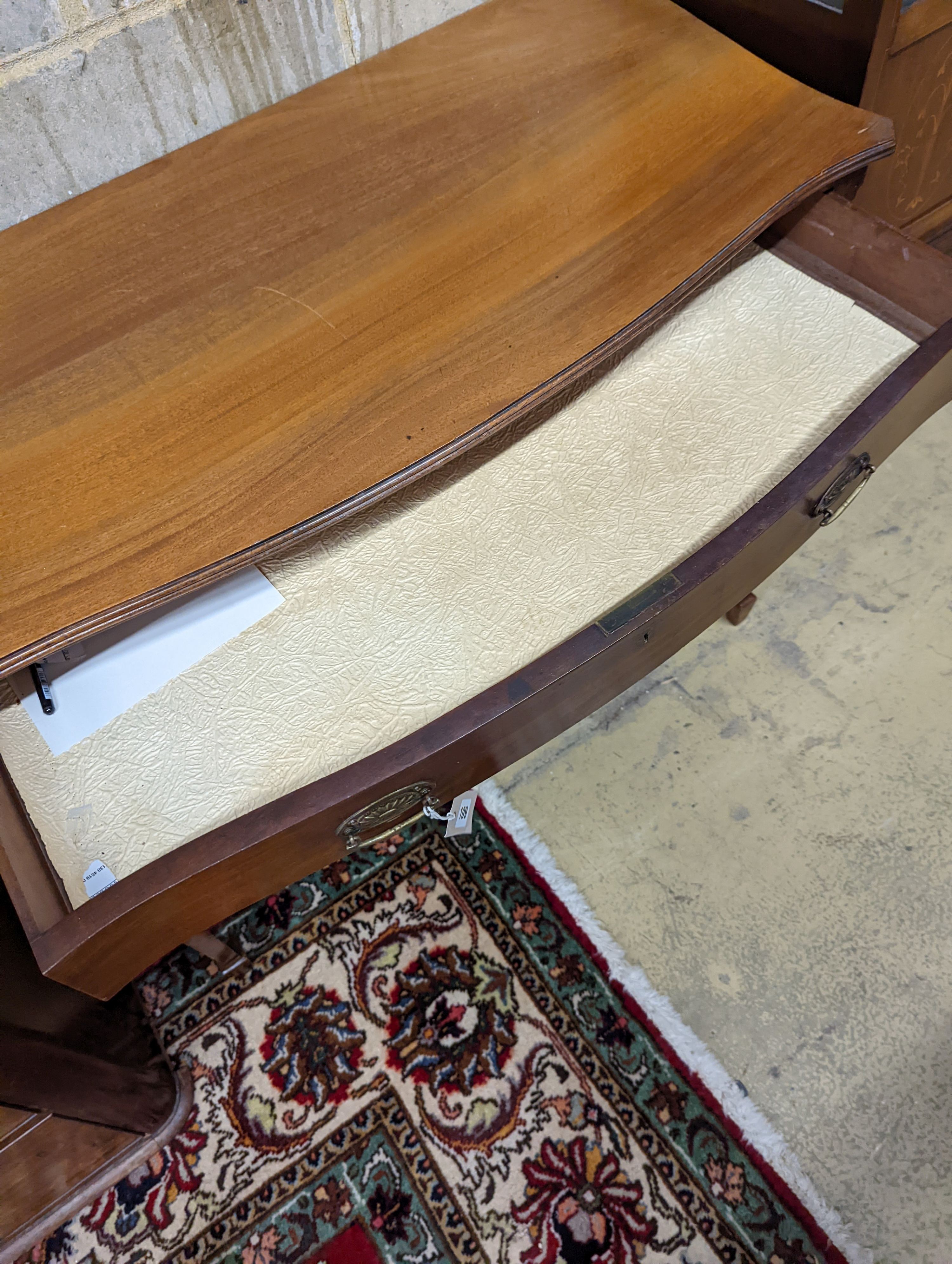 An Edwardian mahogany serpentine kneehole dressing table. W-106cm, D-53cm, H-79cm.